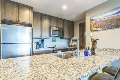 a kitchen with a sink and a refrigerator at Ski & Golf by Sweetheart Stays in Granby