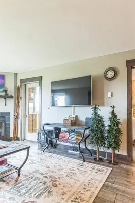 a living room with a flat screen tv on a wall at Ski & Golf by Sweetheart Stays in Granby