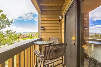 a balcony with two chairs and a table at Ski & Golf by Sweetheart Stays in Granby