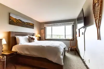 a bedroom with a large white bed and a window at Ski & Golf by Sweetheart Stays in Granby