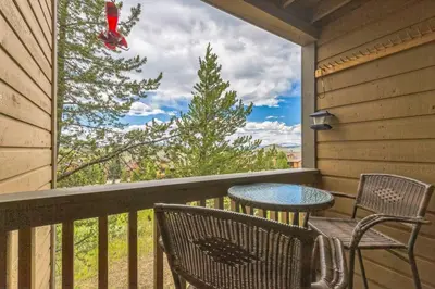 a balcony with a table and chairs and a tree at Ski & Golf by Sweetheart Stays in Granby