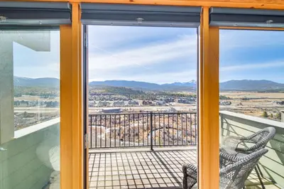 a view from the balcony of a house with a chair at Private Sauna! Spacious Ski Condo Near Winter Park in Fraser