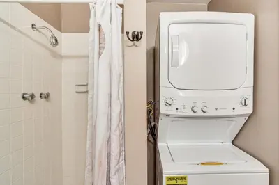a bathroom with a washer and dryer next to a toilet at Private Sauna! Spacious Ski Condo Near Winter Park in Fraser