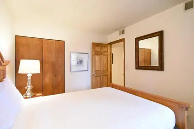 a bedroom with a white bed and a mirror at Mountainside Aspenview Condo - Great Year-Round Location in Frisco
