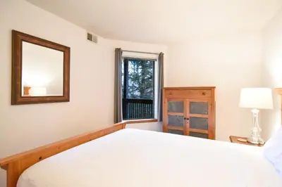 a bedroom with a bed and a mirror and a window at Mountainside Aspenview Condo - Great Year-Round Location in Frisco