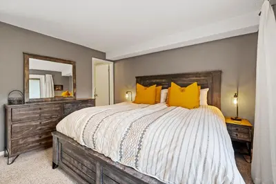 a bedroom with a large bed with yellow pillows at Key Condo Slopeside - Walk to Lifts, Pool/Hot Tub, Fantastic Views in Keystone