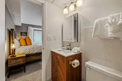 a bathroom with a sink and a bedroom with a bed at Key Condo Slopeside - Walk to Lifts, Pool/Hot Tub, Fantastic Views in Keystone