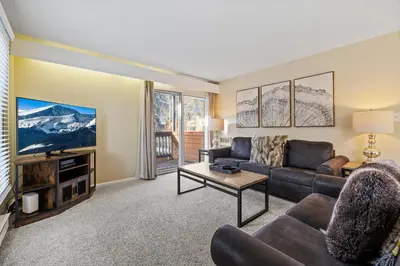 a living room with a couch and a tv at Key Condo Slopeside - Walk to Lifts, Pool/Hot Tub, Fantastic Views in Keystone