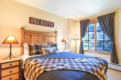 a bedroom with a ski house sign above a bed at The Springs at River Run - Walk to Lifts, Pool Hot Tubs in Keystone