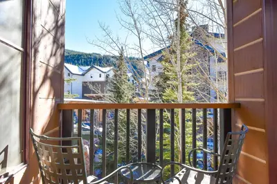 two chairs sitting on a balcony looking out of a window at The Springs at River Run - Walk to Lifts, Pool Hot Tubs in Keystone