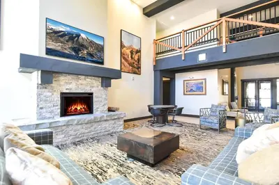 a living room with couches and a fireplace at The Springs at River Run - Walk to Lifts, Pool Hot Tubs in Keystone