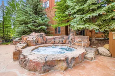 a large stone tub in front of a house at The Springs at River Run - Walk to Lifts, Pool Hot Tubs in Keystone