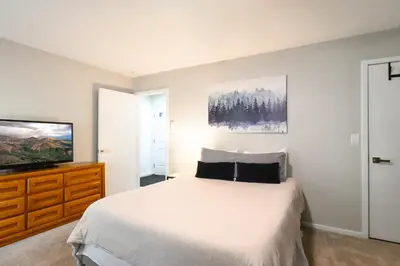 a bedroom with a bed and a flat screen tv at Windwood Bluebird Townhome - Walk to Town, Close to Everything in Frisco