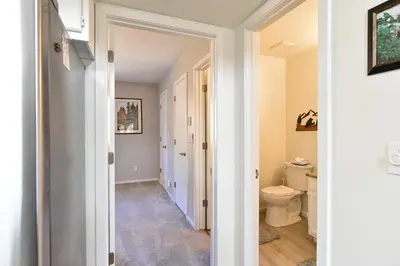 a hallway leading to a bathroom with a toilet at Windwood Bluebird Townhome - Walk to Town, Close to Everything in Frisco