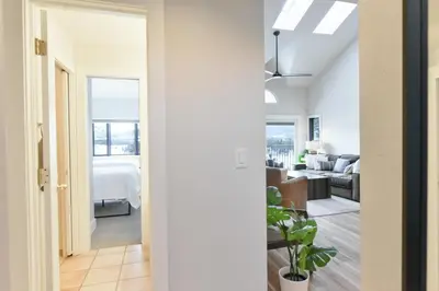a hallway leading to a bedroom with a bed and a living room at Lake Forest Alpine View: Lake Mountain Views in Frisco