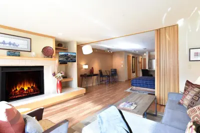 a living room with a fireplace and a bedroom at Liftside Condo - Walk to Lifts, Pool Hot Tub in Keystone