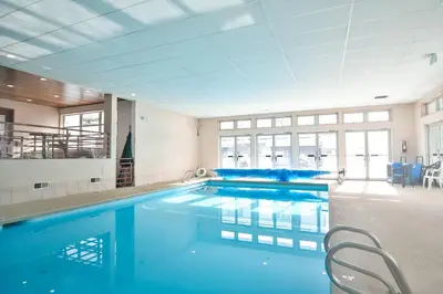 a large swimming pool with blue water in a building at Liftside Condo - Walk to Lifts, Pool Hot Tub in Keystone