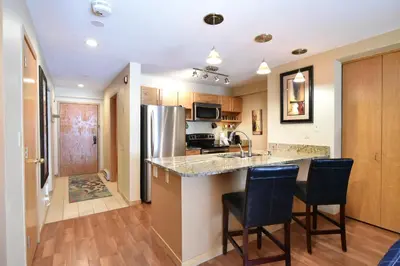 a kitchen with a counter and two bar chairs at Liftside Condo - Walk to Lifts, Pool Hot Tub in Keystone