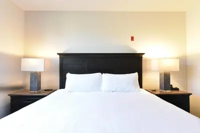 a bedroom with a white bed with two lamps at Red Hawk Townhome - Walk to Lifts, Pool/Hot Tub Access in Keystone