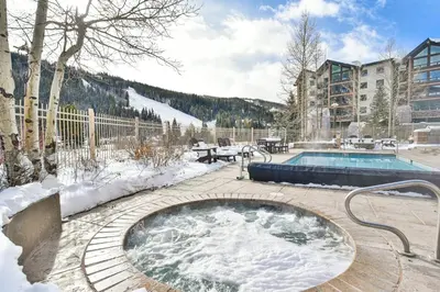 a hot tub in the snow next to a pool at Red Hawk Townhome - Walk to Lifts, Pool/Hot Tub Access in Keystone