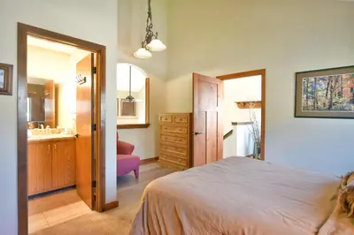 a bedroom with a bed and a bathroom with a sink at Centennial Townhome - Mountain/Lake Views Pool Access in Dillon