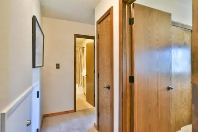 a hallway with a wooden door in a house at Centennial Townhome - Mountain/Lake Views Pool Access in Dillon