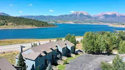 an aerial view of a resort with a lake and mountains at Centennial Townhome - Mountain/Lake Views Pool Access in Dillon