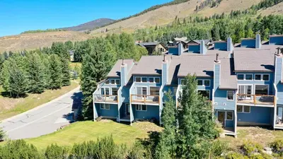 an aerial view of a large house with a driveway at Centennial Townhome - Mountain/Lake Views Pool Access in Dillon