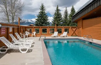 a swimming pool with lounge chairs and a house at Centennial Townhome - Mountain/Lake Views Pool Access in Dillon