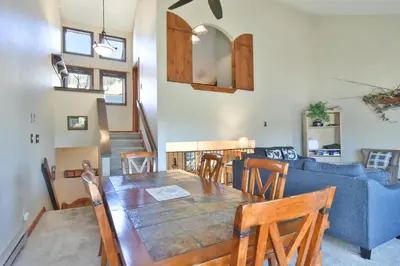 a living room with a table and a blue couch at Centennial Townhome - Mountain/Lake Views Pool Access in Dillon