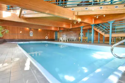 a large swimming pool in a building with wooden ceilings at Timber Ridge Retreat - Pool, Hot Tub, Sauna + More in Silverthorne