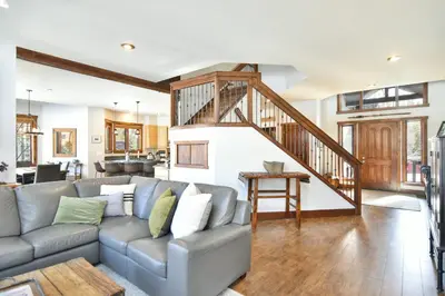 a living room with a couch and a staircase at Shekel Haus – Luxury Mountain Retreat w/ Views Hot Tub in Breckenridge