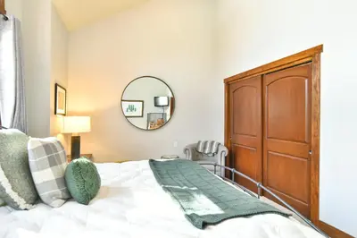 a bedroom with a bed and a mirror at Shekel Haus – Luxury Mountain Retreat w/ Views Hot Tub in Breckenridge