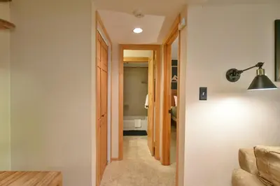 a hallway leading into a room with a door and a lamp at Wild Irishman RR Chalet: Fantastic Keystone Getaway in Keystone