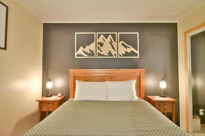 a bedroom with a bed with two nightstands and two lamps at Wild Irishman RR Chalet: Fantastic Keystone Getaway in Keystone
