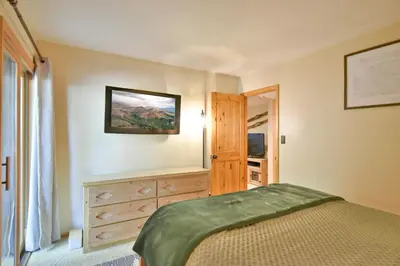 a bedroom with a bed and a dresser and a window at Wild Irishman RR Chalet: Fantastic Keystone Getaway in Keystone