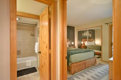 a bedroom with a bed and a bathroom with a tub at Wild Irishman RR Chalet: Fantastic Keystone Getaway in Keystone