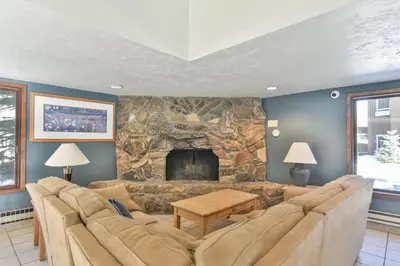 a living room with a couch and a stone fireplace at Wild Irishman RR Chalet: Fantastic Keystone Getaway in Keystone