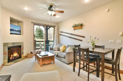 a living room with a table and a fireplace at Highland Greens Retreat: Great Location, Near Shuttle Stops in Breckenridge