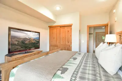 a bedroom with a large bed with a flat screen tv at Highland Greens Retreat: Great Location, Near Shuttle Stops in Breckenridge