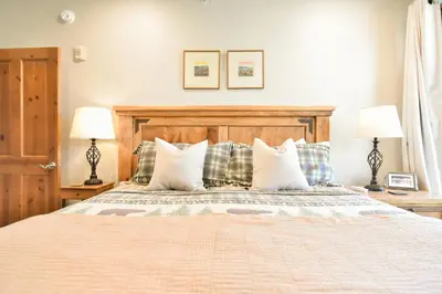 a bedroom with a bed with pillows and two lamps at Highland Greens Retreat: Great Location, Near Shuttle Stops in Breckenridge