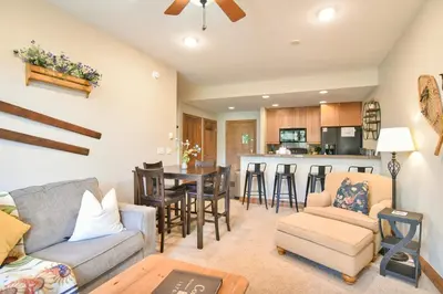 a living room with a couch and a table at Highland Greens Retreat: Great Location, Near Shuttle Stops in Breckenridge