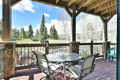 a patio with a table and chairs on a deck at Highland Greens Retreat: Great Location, Near Shuttle Stops in Breckenridge