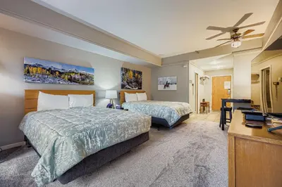 a hotel room with two beds and a desk at 2747 Slopeside studio in Keystone