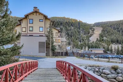 a house on a bridge with a building on a mountain at 2747 Slopeside studio in Keystone