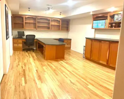 an office with a desk and a computer on a wooden floor at Private Basement Suite Bedrooms Bath Kitchen office Theater in Broomfield