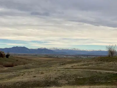 a view of a field with mountains in the distance at Private Basement Suite Bedrooms Bath Kitchen office Theater in Broomfield