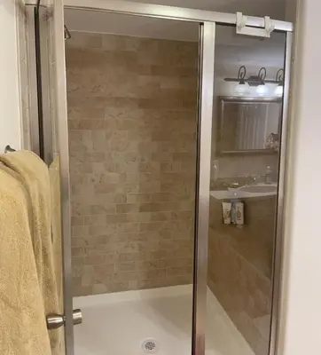 a glass shower in a bathroom with a sink at Private Basement Suite Bedrooms Bath Kitchen office Theater in Broomfield