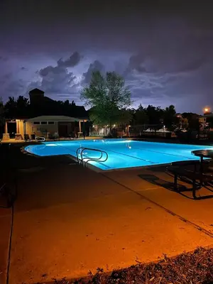 a large blue swimming pool at night at Private Basement Suite Bedrooms Bath Kitchen office Theater in Broomfield