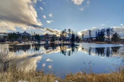 a view of a lake with houses in the background at 3BR Riverfront Retreat! Mtn Views, Community Perks in Winter Park